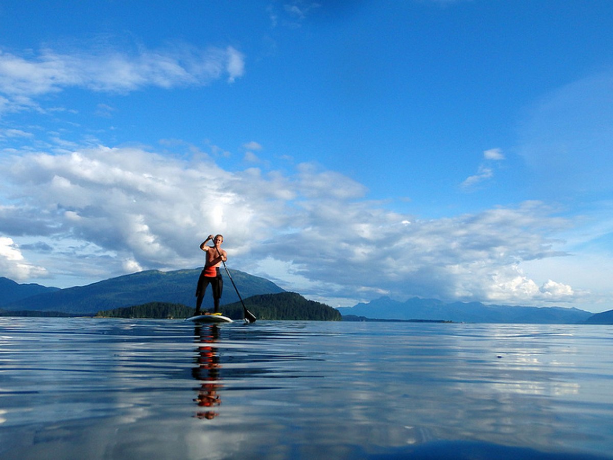 a man standing next to a body of water